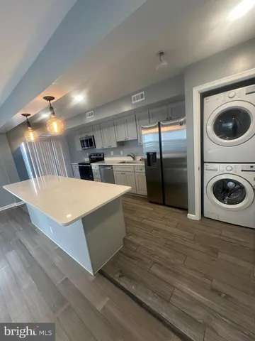 a kitchen with stainless steel appliances granite countertop a refrigerator a sink and a stove