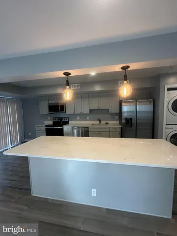 a view of kitchen with stainless steel appliances wooden floor