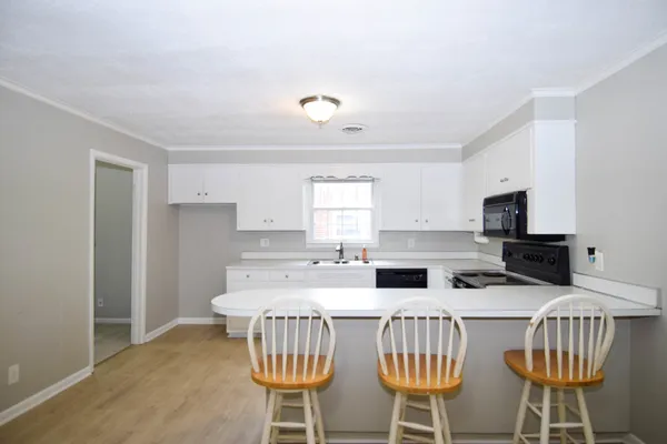 a kitchen with stainless steel appliances a stove a sink refrigerator and a dining table