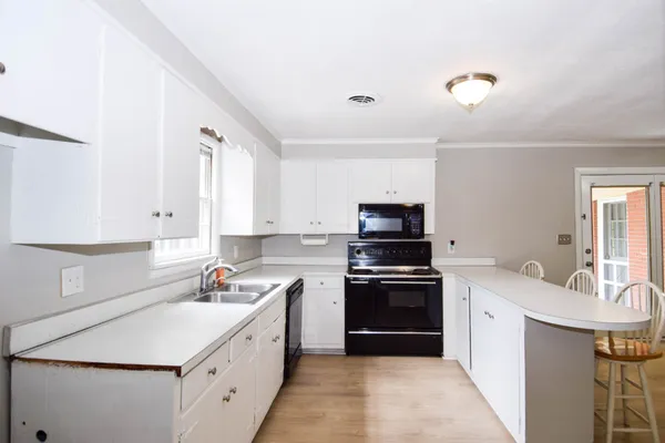a kitchen that has a sink and a stove top oven