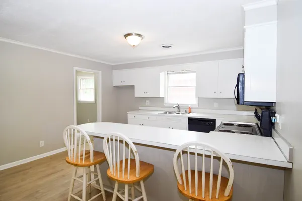 a kitchen with a dining table chairs and a refrigerator