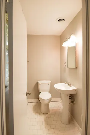 a bathroom with a toilet sink and mirror