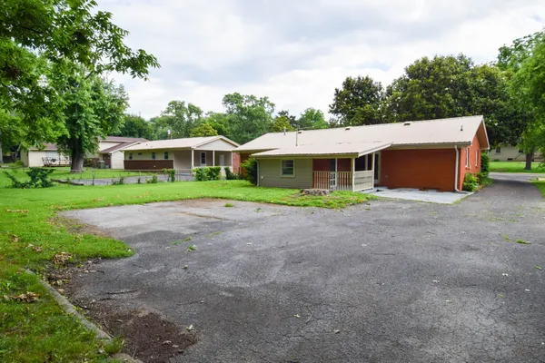 a front view of a house with a yard and trees