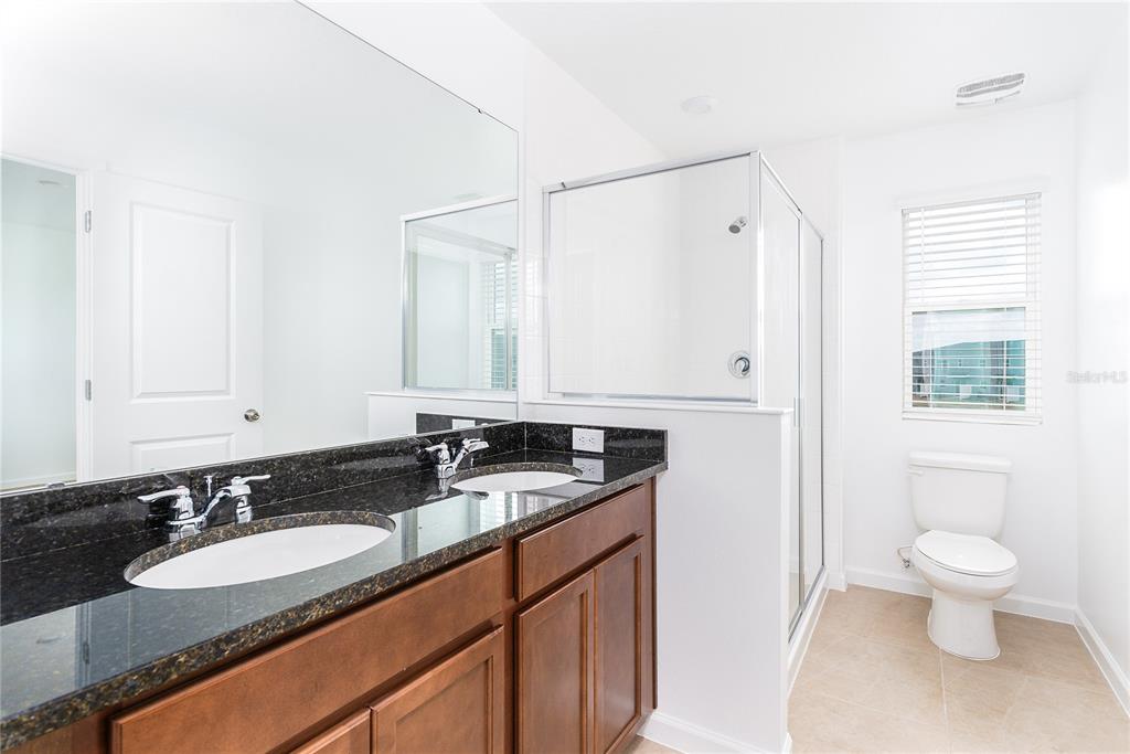 987 Spring Palms Loop Orlando, FL 32828 - Photo 13 of 22 a bathroom with a granite countertop sink and a mirror