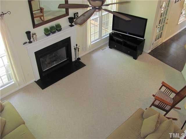 12224 Breton Lane Raleigh, NC 27613 - Photo 12 of 25 a living room with furniture a flat screen tv and a fireplace