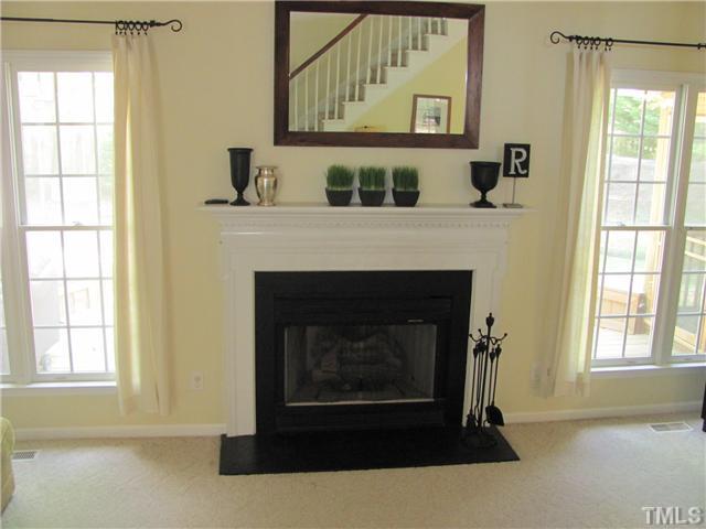 12224 Breton Lane Raleigh, NC 27613 - Photo 25 of 25 a living room with a fireplace and windows