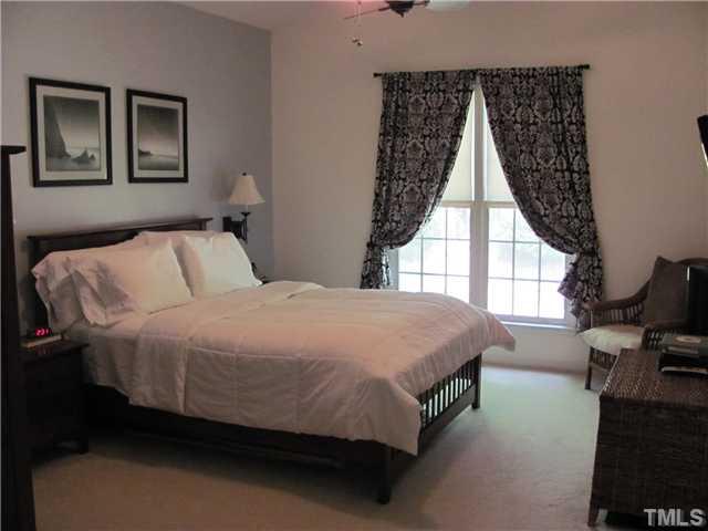 12224 Breton Lane Raleigh, NC 27613 - Photo 13 of 25 a spacious bedroom with a bed and wooden floor