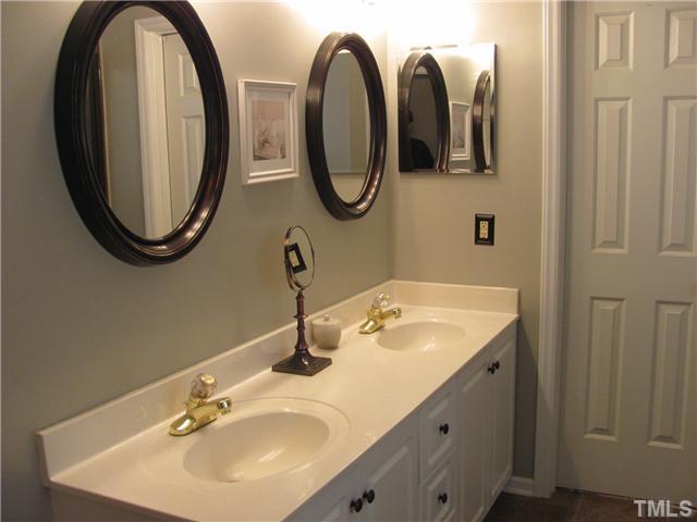 12224 Breton Lane Raleigh, NC 27613 - Photo 14 of 25 a bathroom with a mirror and a sink