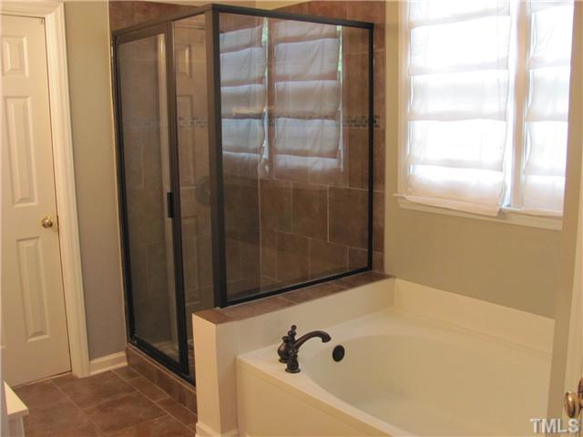 12224 Breton Lane Raleigh, NC 27613 - Photo 15 of 25 a bathroom with a tub and shower