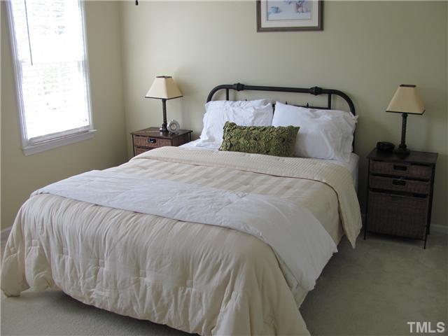 12224 Breton Lane Raleigh, NC 27613 - Photo 16 of 25 a bedroom with a bed and a lamp