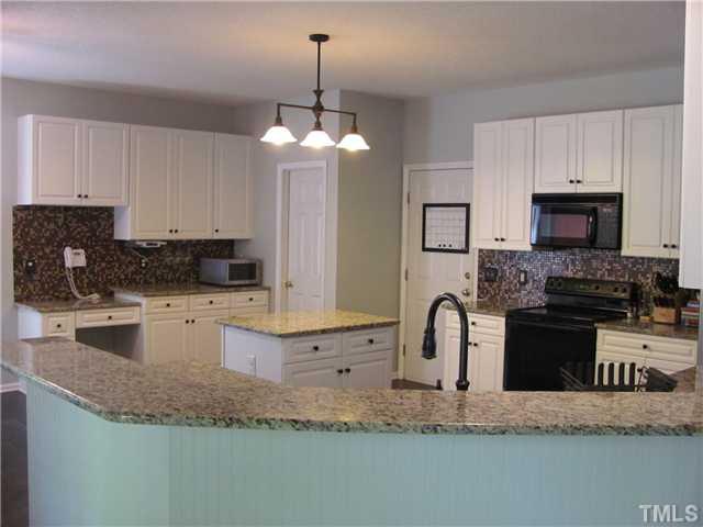 12224 Breton Lane Raleigh, NC 27613 - Photo 7 of 25 a kitchen with granite countertop a sink a counter top space appliances and cabinets