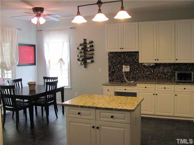 12224 Breton Lane Raleigh, NC 27613 - Photo 8 of 25 a kitchen with a table chairs and white cabinets