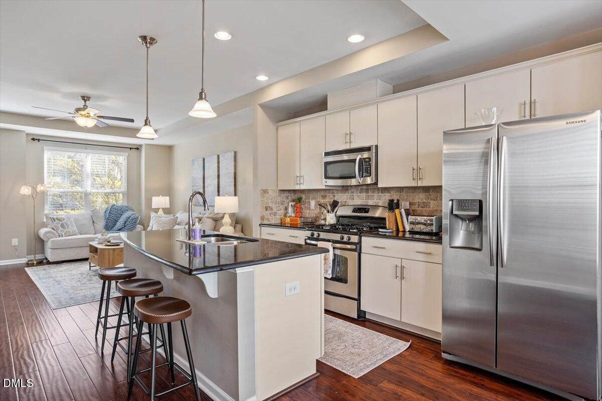 1427 Crafton Way Raleigh, NC 27607 - Photo 8 of 26 a kitchen with kitchen island a counter top space a sink appliances and cabinets