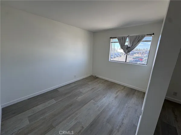 an empty room with wooden floor and window