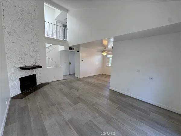 a view of empty room with wooden floor and fireplace