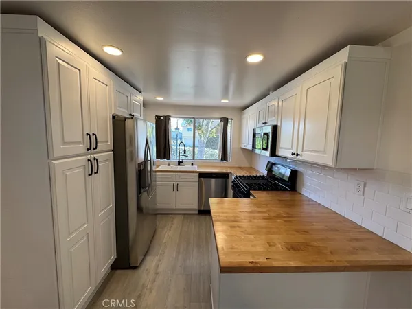 a kitchen with stainless steel appliances granite countertop a refrigerator sink and cabinets