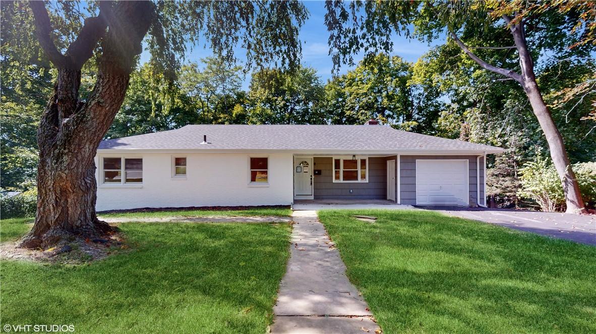 a view of a yard in front of a house with large tree