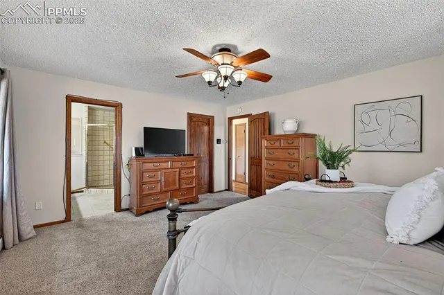 a bedroom with a bed a flat screen tv and a window