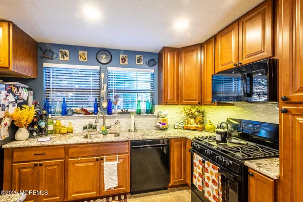 a kitchen with stainless steel appliances granite countertop a sink stove and cabinets