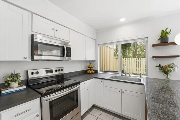 a kitchen with granite countertop cabinets stainless steel appliances and wooden floor