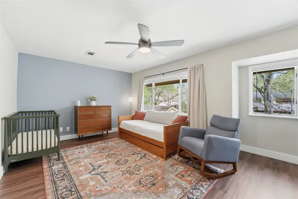 a bedroom with furniture wooden floor and window