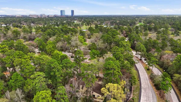 an aerial view of residential houses with outdoor space and trees