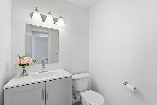 a bathroom with a sink vanity mirror and toilet