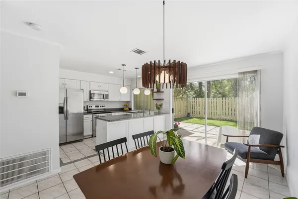 a kitchen with a table chairs and a chandelier