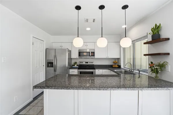 a kitchen with stainless steel appliances granite countertop a sink a counter space and cabinets
