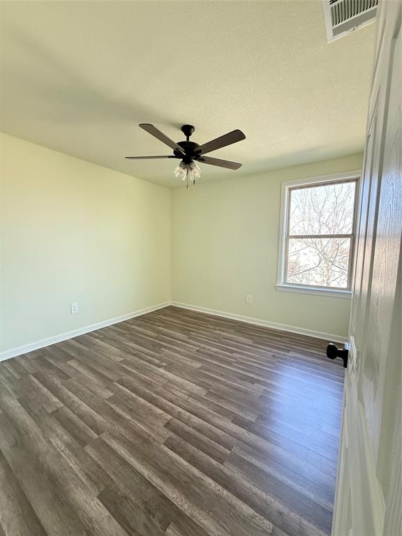 2864 Burchill Road Fort Worth, TX 76105 - Photo 12 of 26 an empty room with wooden floor fan and windows