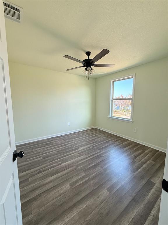 2864 Burchill Road Fort Worth, TX 76105 - Photo 13 of 26 an empty room with wooden floor fan and windows