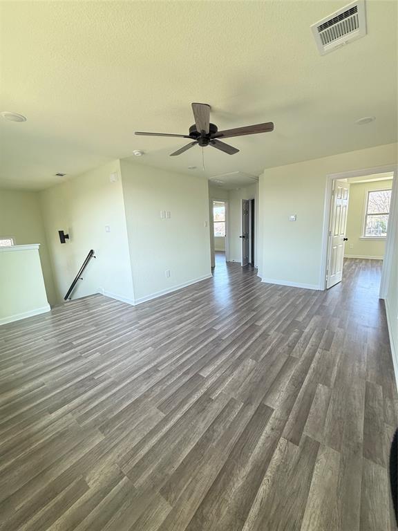 2864 Burchill Road Fort Worth, TX 76105 - Photo 18 of 26 a view of a room with wooden floor and a ceiling fan