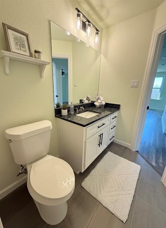 2864 Burchill Road Fort Worth, TX 76105 - Photo 23 of 26 a bathroom with a granite countertop toilet sink and mirror