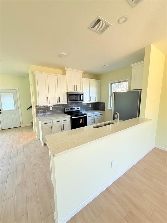 2864 Burchill Road Fort Worth, TX 76105 - Photo 4 of 26 a large kitchen with stainless steel appliances granite countertop a stove a refrigerator a sink a microwave and cabinets