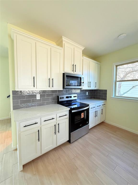 2864 Burchill Road Fort Worth, TX 76105 - Photo 5 of 26 a kitchen with stainless steel appliances granite countertop a stove a sink and a microwave