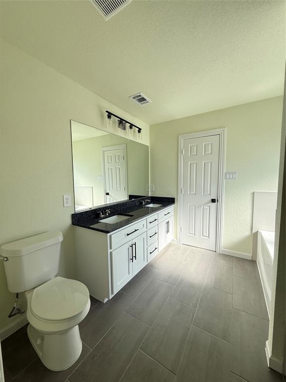 2864 Burchill Road Fort Worth, TX 76105 - Photo 8 of 26 a spacious bathroom with a granite countertop sink a toilet and mirror