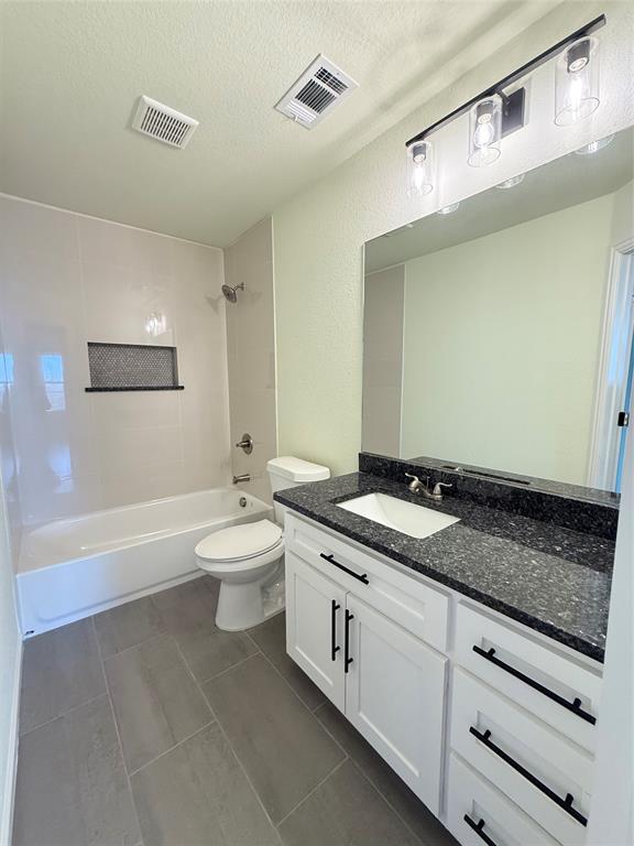 2864 Burchill Road Fort Worth, TX 76105 - Photo 9 of 26 a bathroom with a granite countertop sink a toilet a mirror and bathtub