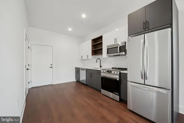 a kitchen with stainless steel appliances a stove a microwave and sink