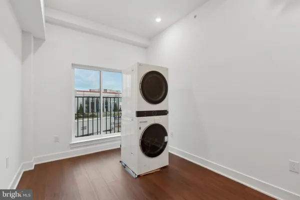 a view of a small space with wooden floor washing machine and dryer