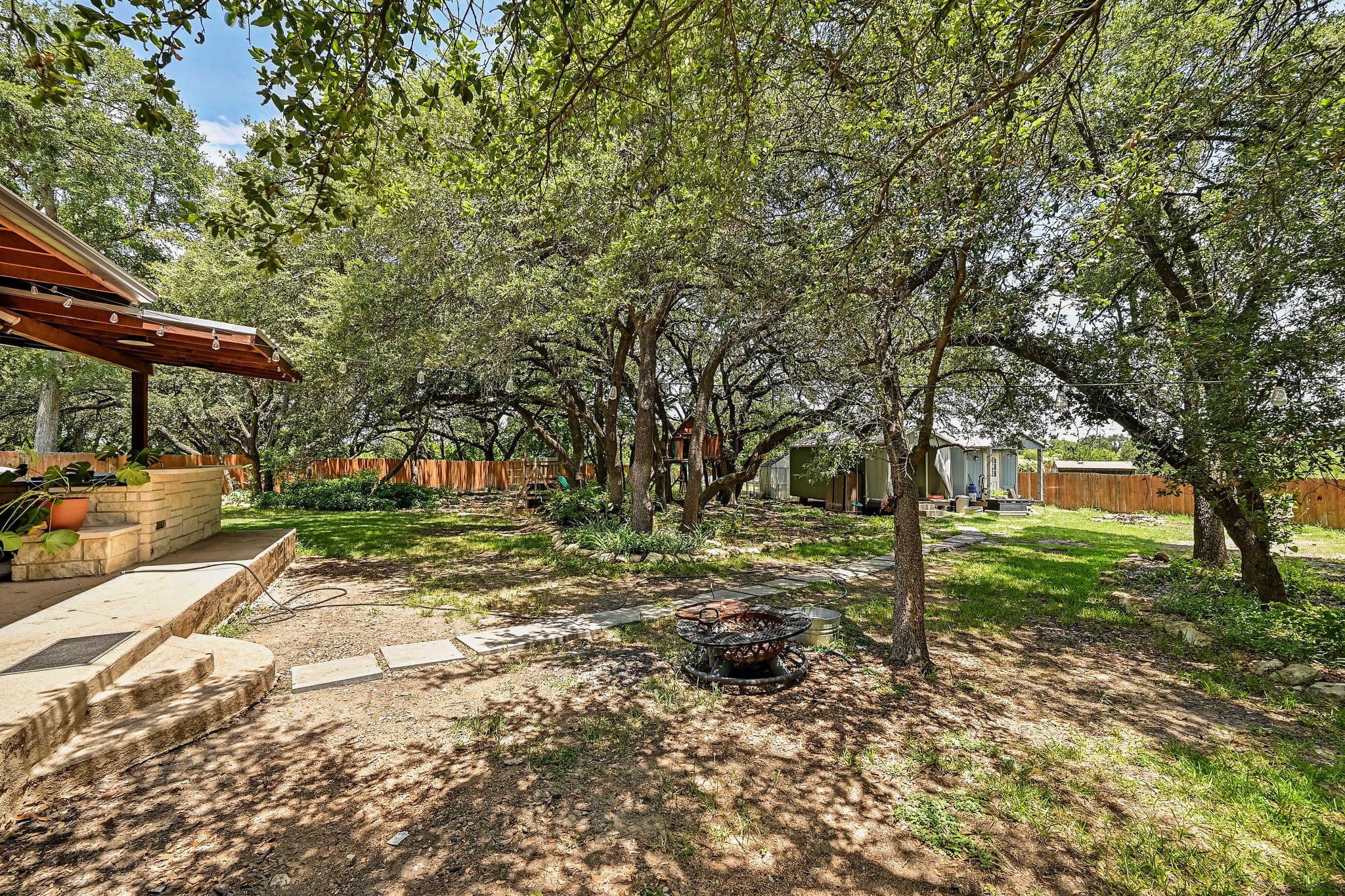104 North Sumac Lane Georgetown, TX 78633 - Photo 39 of 40 Mature trees shade a private yard with a cozy fire pit and ample space for relaxation.