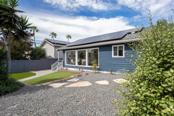 a view of a house with backyard and sitting area
