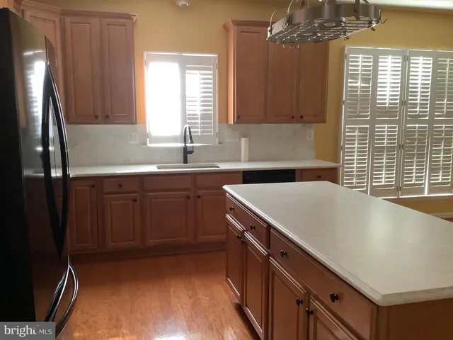 a kitchen with a sink a window and cabinets