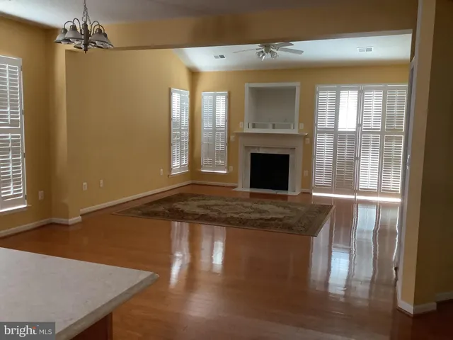 a view of a livingroom with wooden floor and a fireplace