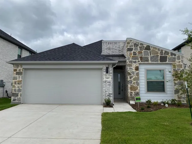 a front view of a house with a garden and garage