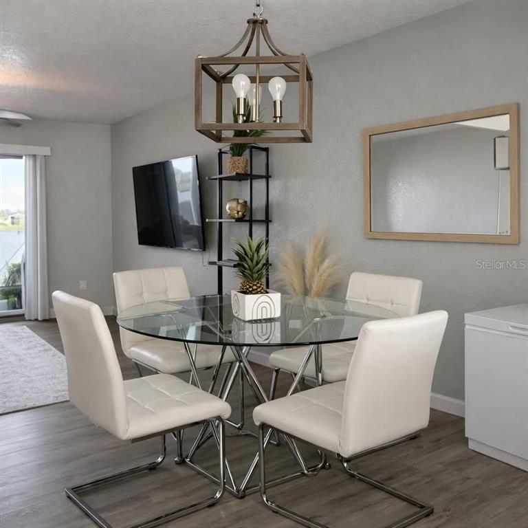 26272 Rampart Boulevard, Unit G107 Punta Gorda, FL 33983 - Photo 8 of 11 a view of a dining room with furniture and wooden floor