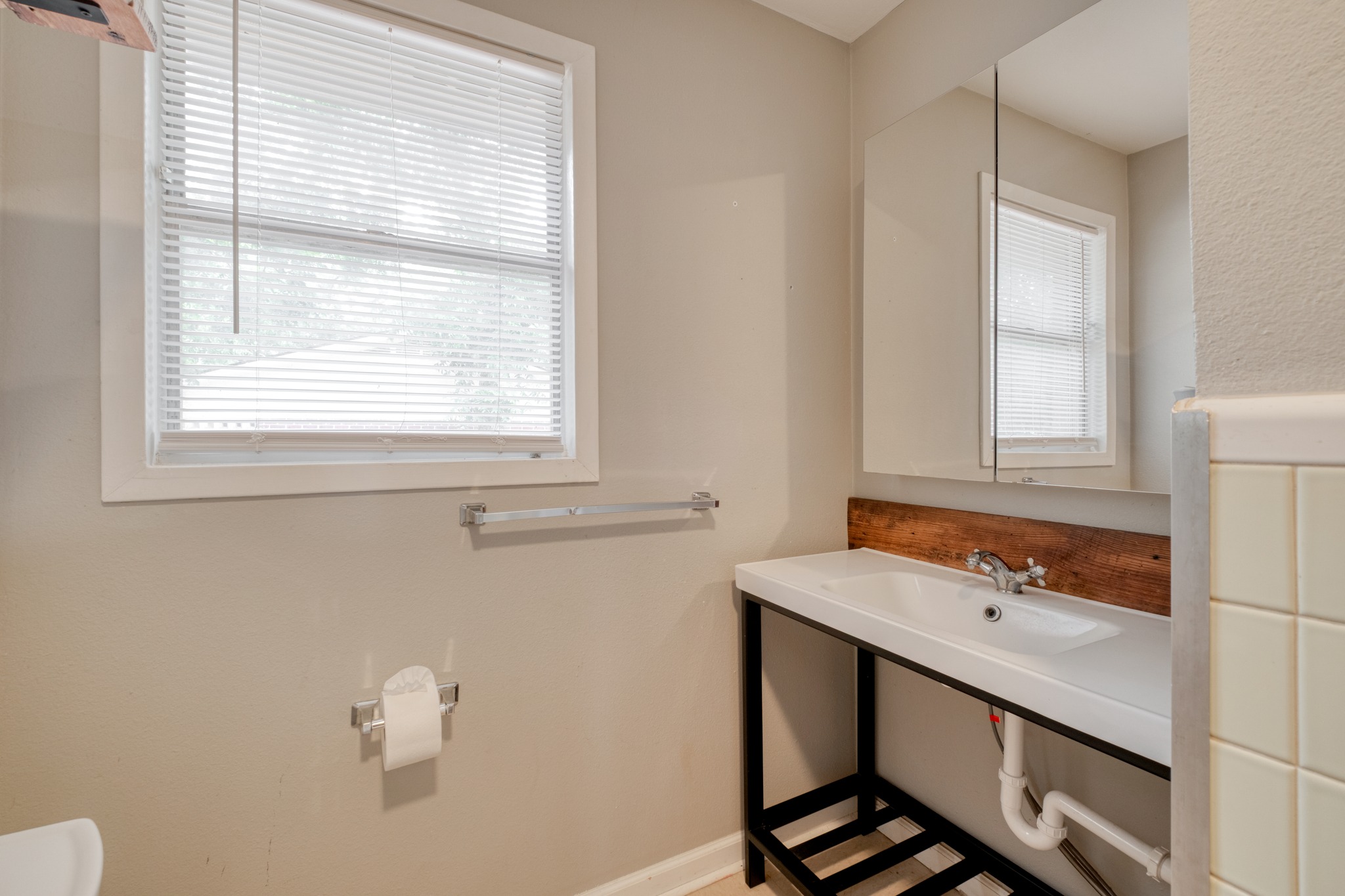 707 North Main Street Elgin, TX 78621 - Photo 9 of 21 Bathroom vanity with a modern sink and open shelf and a window providing natural light