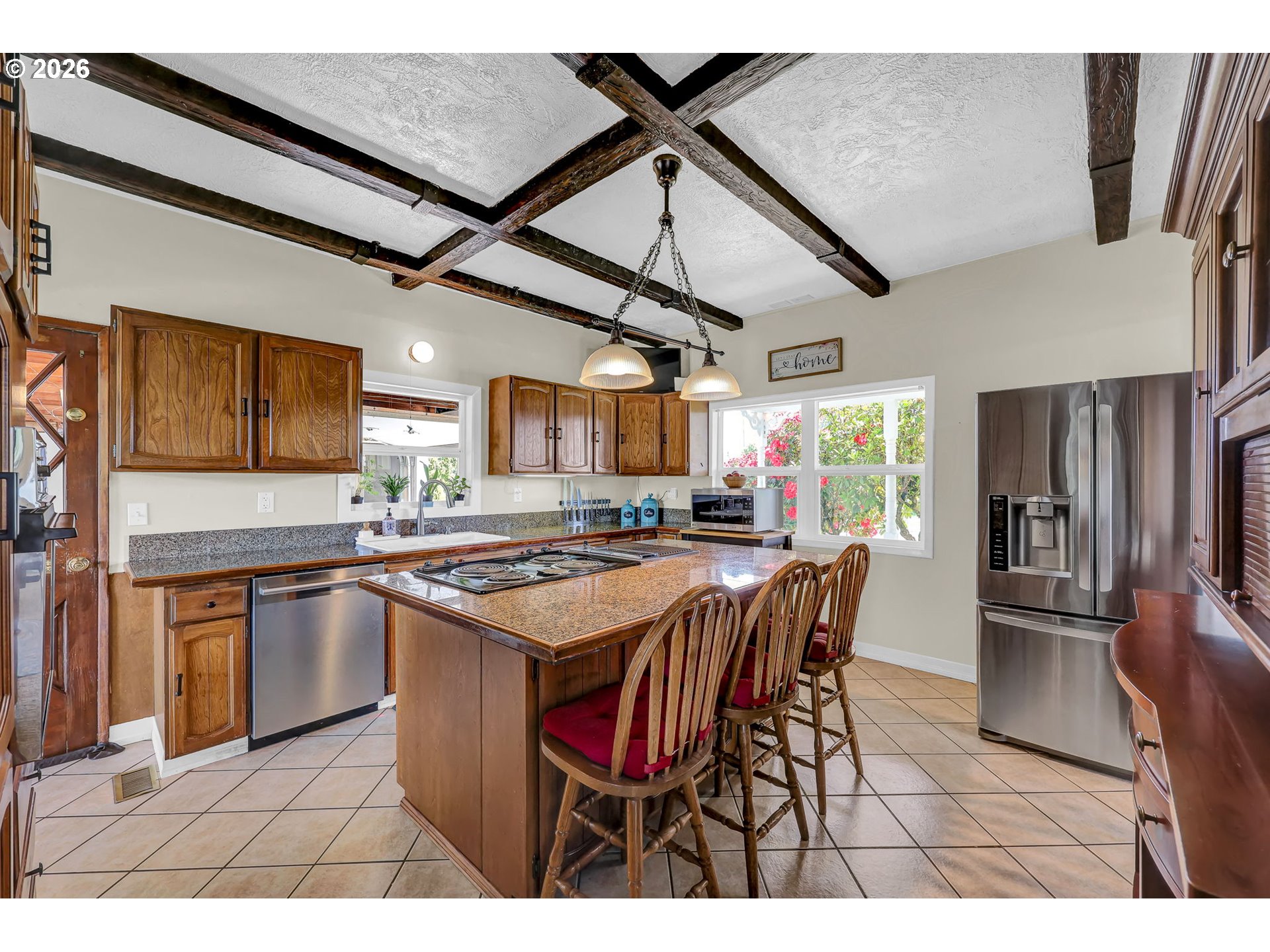 90440 Goodman Road Junction City, OR 97448 - Photo 9 of 48 a kitchen with stainless steel appliances granite countertop a table chairs and a refrigerator