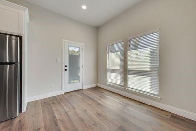 721 North Jefferson Street Pilot Point, TX 76258 - Photo 4 of 12 an empty room with wooden floor and windows