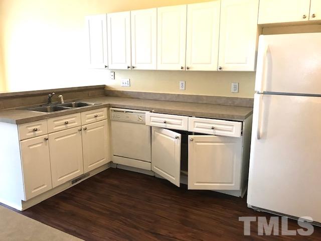 3832 Pin Oak Road Raleigh, NC 27604 - Photo 3 of 14 a kitchen with wooden cabinets and white appliances