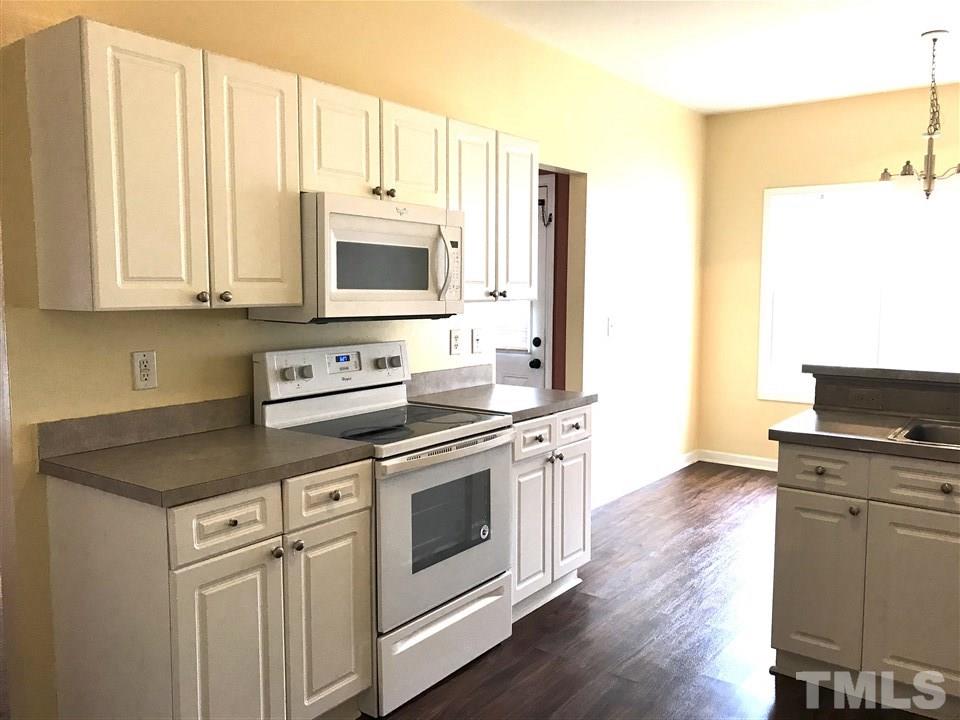 3832 Pin Oak Road Raleigh, NC 27604 - Photo 6 of 14 a kitchen with stainless steel appliances granite countertop a stove a sink and a microwave